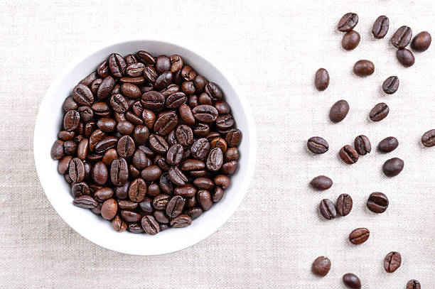 istock Roasted  Arabica coffee beans, in a white bowl, on linen 2234886757