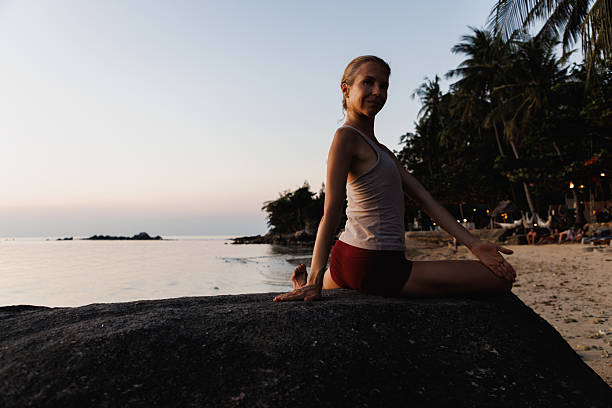 istock Woman practicing yoga at a tropical beach during sunset 2234888682