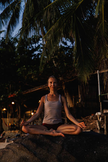 istock Woman practicing yoga at sunset on a tropical beach 2234888720