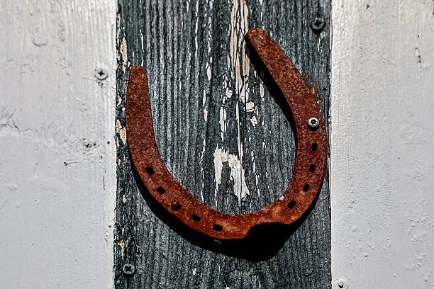 istock Rusty horseshoe hanging on weathered wooden wall bringing good luck 2234889034
