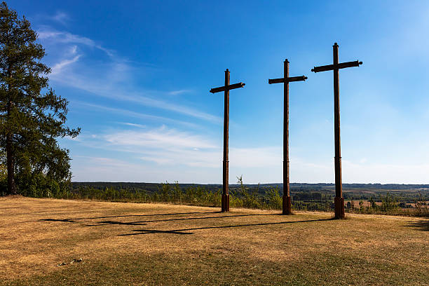istock Three wooden crosses on hilltop under wide blue sky 2234890159