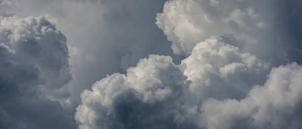 istock thick fluffy cumulus clouds against dramatic overcast sky. cloudscape photo for natural background in anamorphic widescreen cinema format. aspect ratio 21:9 2234892838