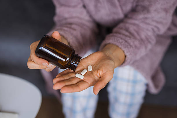istock Woman pouring pills from a bottle into her hand 2234895005