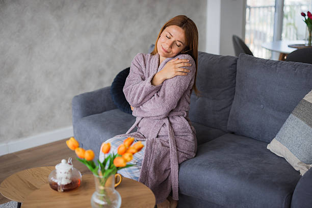 istock Serene woman embracing herself on sofa in cozy home interior 2234897244