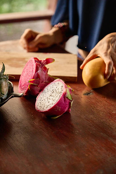 Fresh dragon fruit and mango on wooden table with warm natural lighting