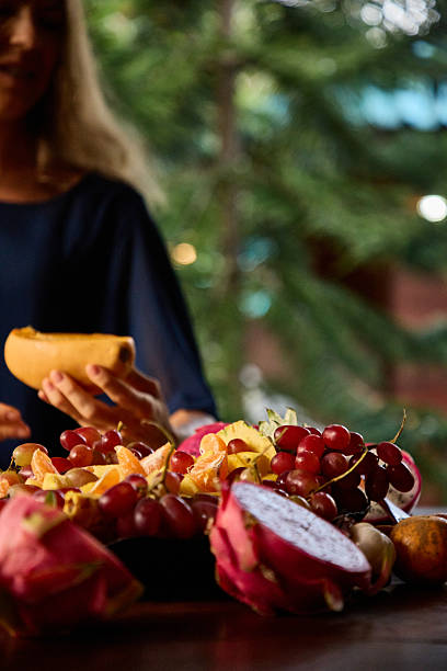 Close-up of assorted fruits on a table with person in blurred background