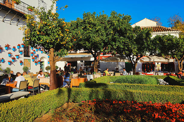 Marbella, Spain - November 20, 2021 - Tourists relaxing at pavement cafes and restaurants in Orange Square, Marbella, Malaga