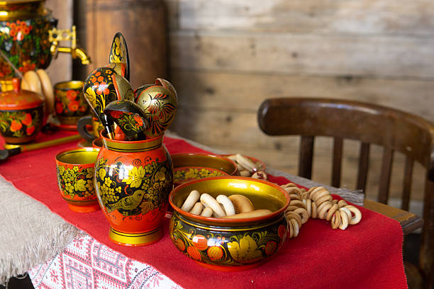Traditional Khokhloma folk craft table setting with samovar, spoons, and snacks. Russian tea drinking food and decorative tableware for cultural design background