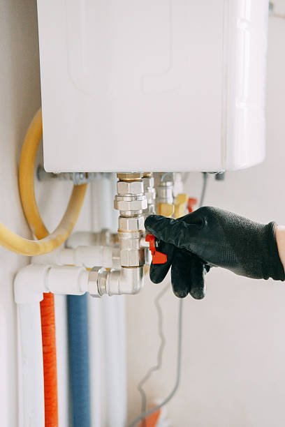 istock Gloved hand adjusts a valve on industrial equipment, showcasing industrial maintenance work. The image highlights the precision and care involved in technical operations. Gas boiler taps. 2234901258