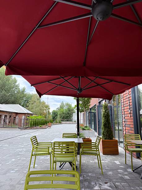 istock Outdoor seating under red umbrella with green chairs 2234904895