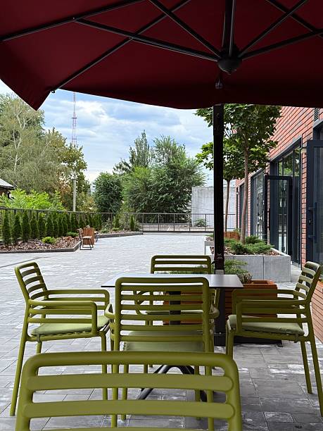 istock Outdoor seating under red umbrella with green chairs 2234904896