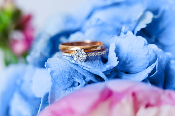 istock Elegant wedding rings showcased on hydrangea blue flowers in a bright setting 2234905512