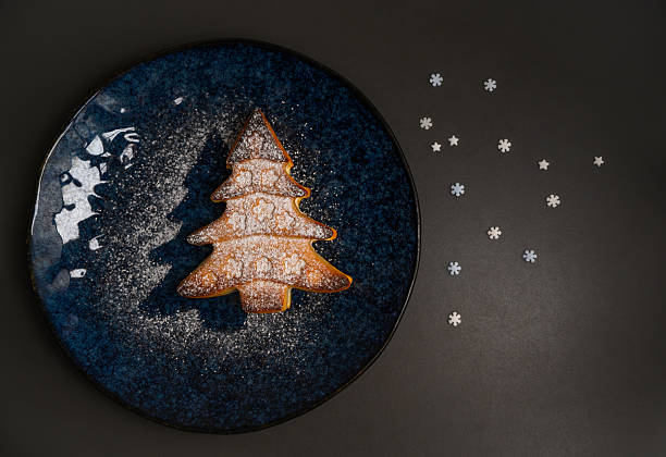 istock Christmas tree cookie with powdered sugar and festive stars on plate 2234906290