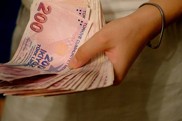 istock A woman holds a stack of 200 Turkish Lira banknotes, close-up. 2234907703