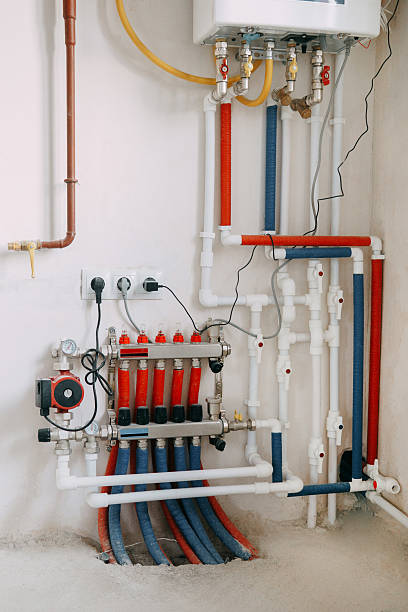 istock Detailed view of an intricate heating system setup featuring red and blue color-coded pipes, valves, and gauges. Connection diagram of a gas boiler with a underfloor heating system. 2234907869