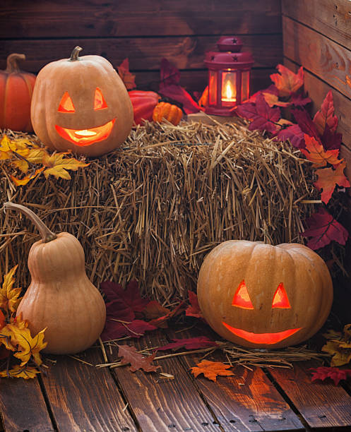 Jack O’ Lanterns glowing on the old wooden background