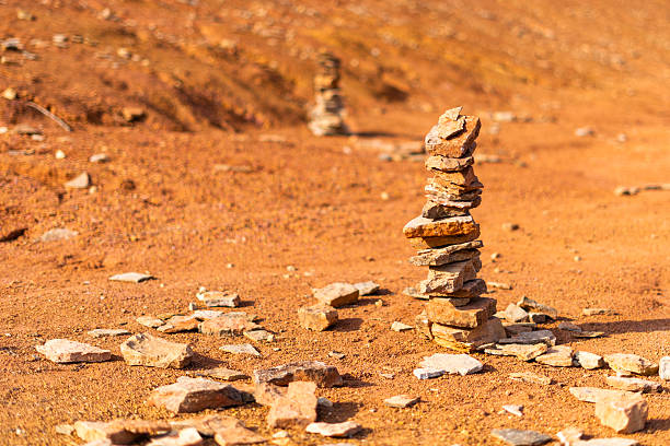 Stones stacked by hikers in a bright orange abandoned bauxite mine