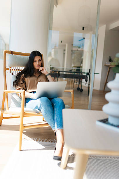 istock Businesswoman working from home sitting on modern chair using laptop 2234908982