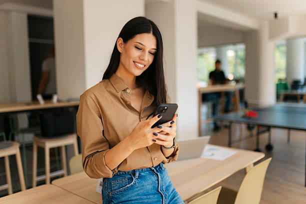 istock Young businesswoman using smartphone in modern office during break time 2234909002