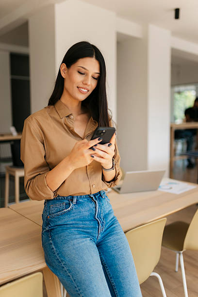 istock Young businesswoman using smartphone in modern office 2234909007