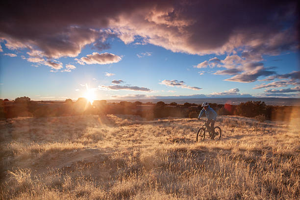 Mature, male, mountain biker following desert track along ridge crest at sunrise, White Ridge Area, Albuquerque New Mexico