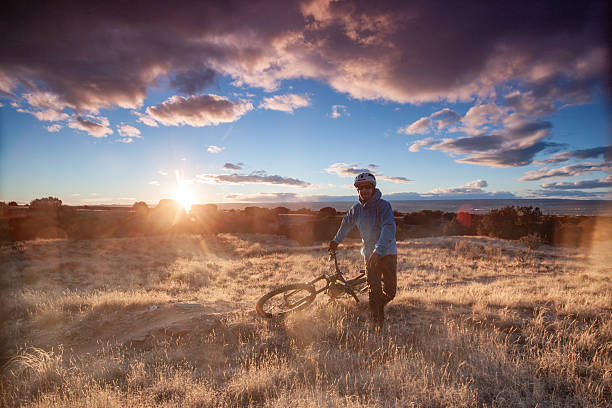 Mature, male, mountain biker following desert track along ridge crest at sunrise, White Ridge Area, Albuquerque New Mexico