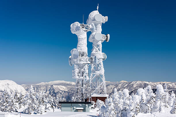 Frozen communications mast covered in snow and ice on a mountaintop in Japan