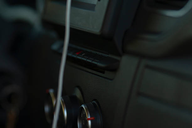A closeup of a cars interior reveals details like the console, control knobs, and a neatly placed charging cable, emphasizing the importance of vehicle technology and organization