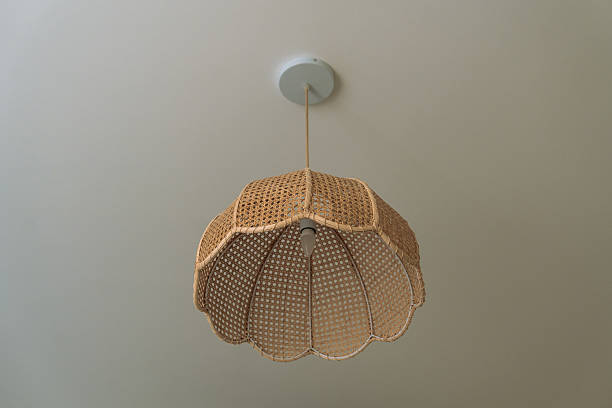 A vintage rattan wicker chandelier on a white ceiling. View from below.