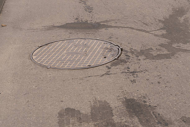 istock A iron hatch with a pattern above an observation well is located on auto road in daytime. Close-up 2234922790