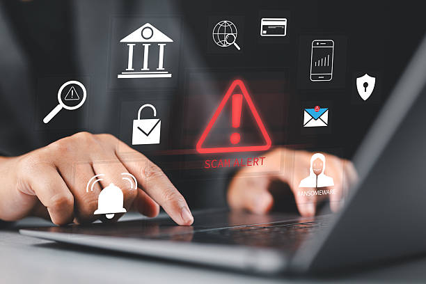 istock Scam alert warning. Cybersecurity concept. Man using laptop, warning sign for scams with icons representing online threats, phishing, and cybersecurity. Unknown person, suspicious scammer, fraud, 2234923739