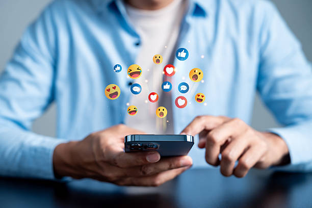 istock Social media engagement with user interacting on smartphone. emoji digital communication, online content sharing, and emotional connection in social platforms. 2234934578