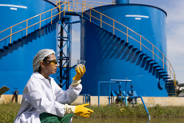 istock Young science Biologist or environmental quality inspector wearing protective gear and white lab coat collecting water sample from Sedimentation pond , water treatment facilities 2234943955