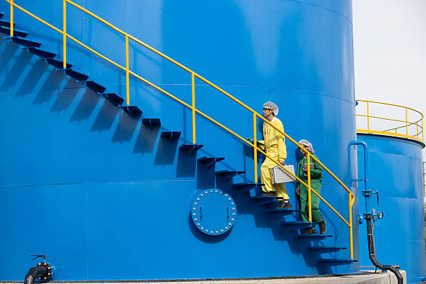 istock Water analysis or science in green and yellow protective clothing handle lab test equipment step up staircase of huge industrial Pulsator Clarifier Tank 2234944011