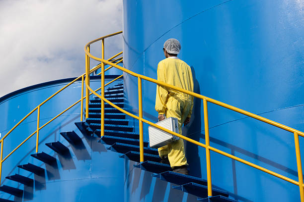 istock Water analysis or science in green and yellow protective clothing handle lab test equipment step up staircase of huge industrial Pulsator Clarifier Tank 2234944035