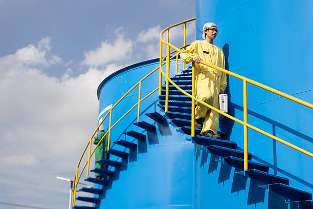 istock Water analysis or science in green and yellow protective clothing handle lab test equipment step up staircase of huge industrial Pulsator Clarifier Tank 2234944048
