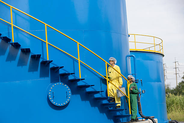 istock Water analysis or science in green and yellow protective clothing handle lab test equipment step up staircase of huge industrial Pulsator Clarifier Tank 2234944068