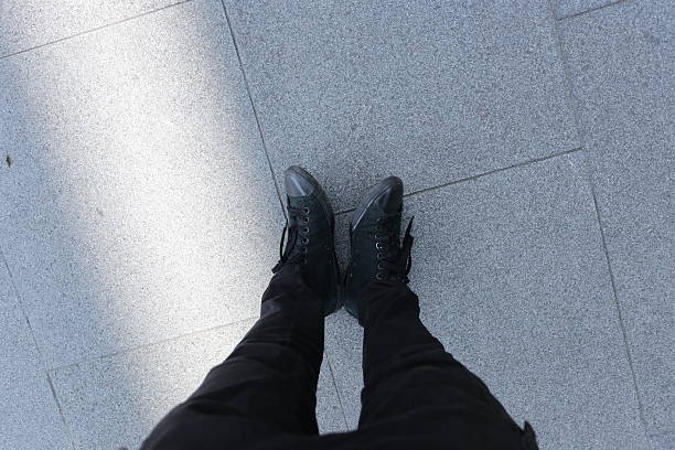 istock Black Shoes Standing on Stone Pavement 2234946861