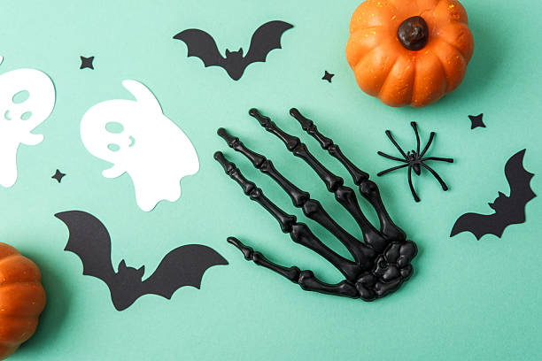 istock Halloween decorations with pumpkins bats ghosts spider skeleton hand on teal background. 2234948897