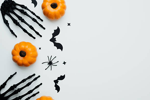 istock Orange pumpkins bats spider skeleton hands white background flat lay festive 2234948904