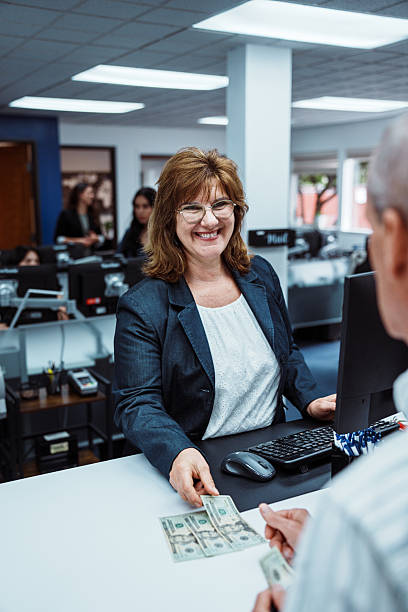 Bank teller counts money for customer