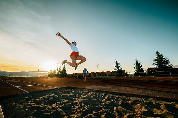 istock Student Athlete Performing Long Jump at Dusk 2234953253