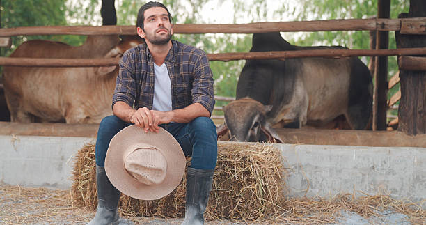 Portrait of adult man in cowboy hat against wooden wall