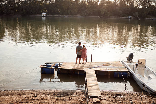 Senior couple enjoying a day on the river pier on a sunset.