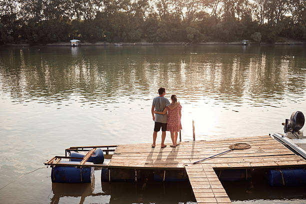 Senior couple enjoying a day on the river pier on a sunset.