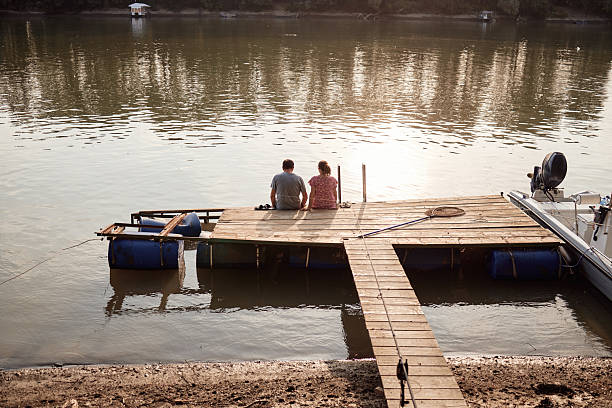 Senior couple enjoying a day on the river pier on a sunset.