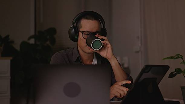 istock Excited Asian Man Feeling Amazed with Joyful Expression Working Late Night Staying Awake with Black Coffee. 2234959446