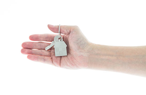 istock Woman hand holding house key on white background 2234965590