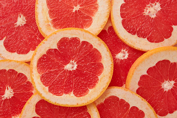 istock Fresh juicy grapefruit slices food background, top view 2234965617
