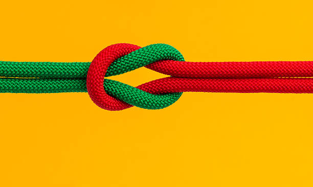 istock Red and green ropes with reef knot isolated on yellow background 2234965646